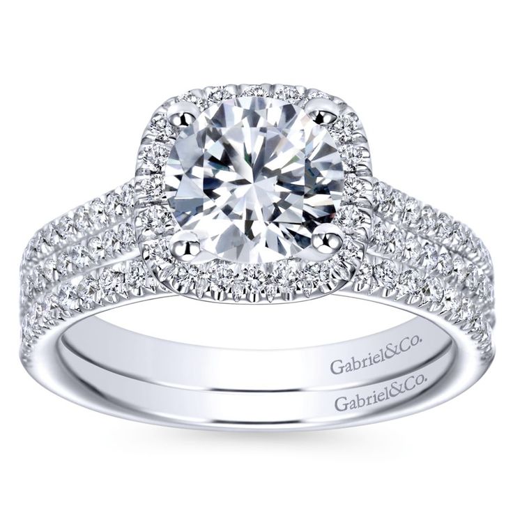 a white gold engagement ring with diamonds on the band and an oval center stone surrounded by round