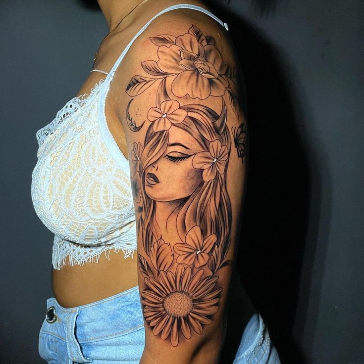 a woman's half sleeve tattoo with flowers on her left arm and the face of a girl