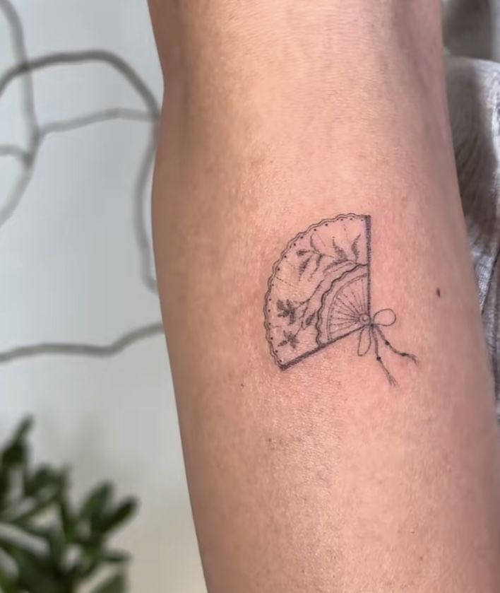 a small tattoo on the arm of a person with a cat in it's head