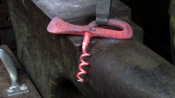 a wrench hanging from the side of a piece of metal