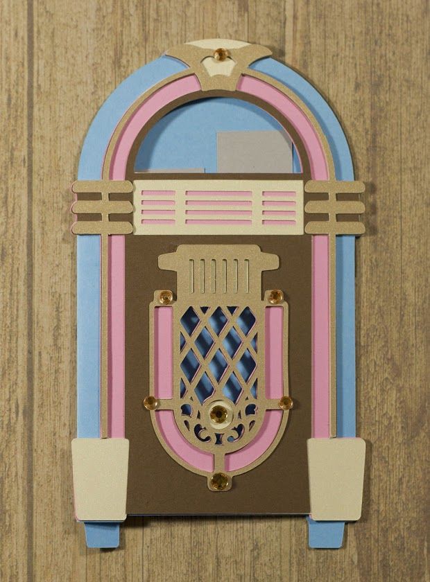 an old fashioned juke box on a wooden surface with blue and pink trimmings