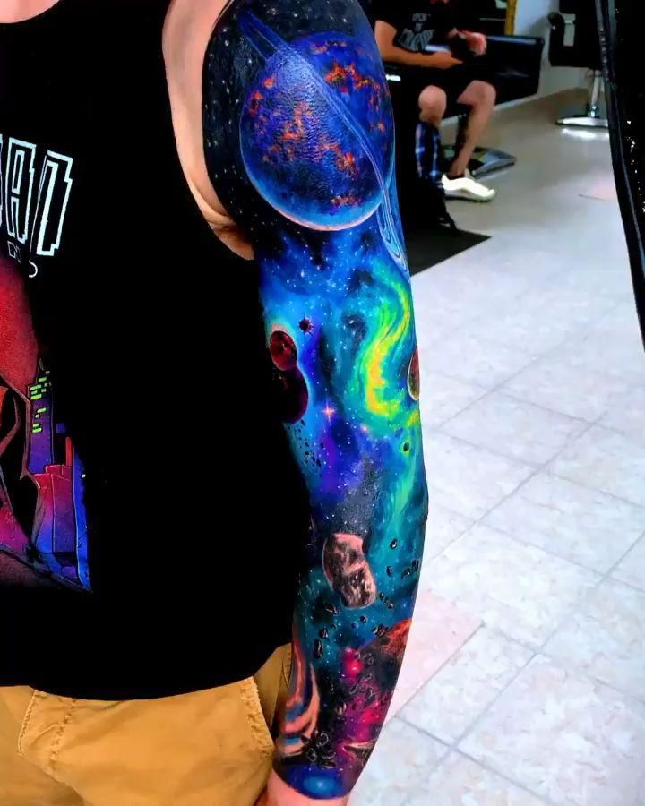 a man with a colorful sleeve tattoo on his arm