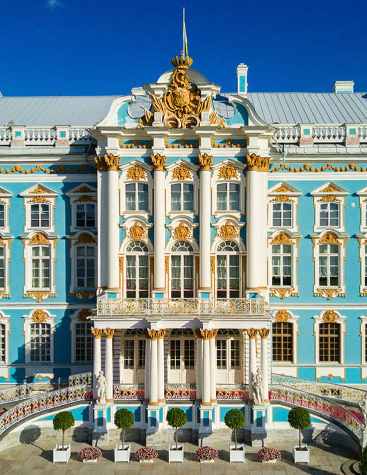 a large blue and white building with gold trim on it's sides, in front of a clear blue sky