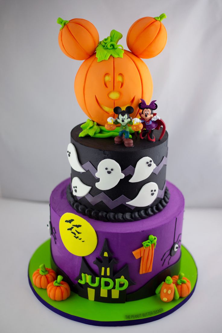 a halloween themed cake with mickey mouse on top