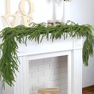 a mantel decorated with greenery and love spelled on the mantle in front of a fireplace