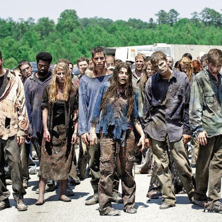 the walking dead cast is standing in front of a group of people with blood on their faces