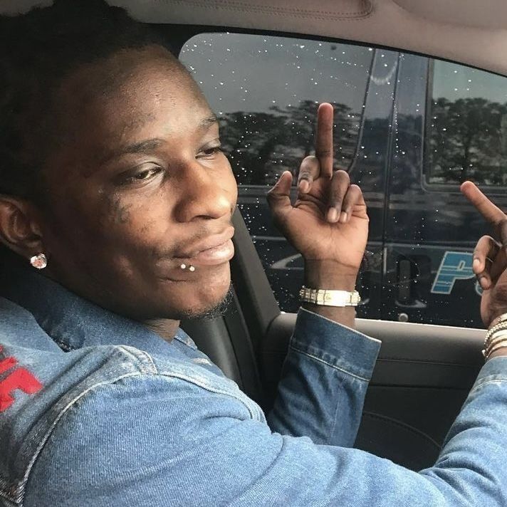 a man sitting in his car making the peace sign