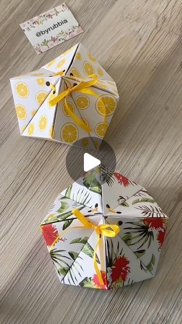 an origami box with lemons and leaves on it, sitting on the floor