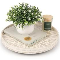 a small potted plant sitting on top of a white plate next to a book