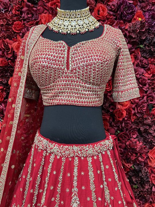 Go all out in this whimsical lehenga, studded with precious mirror, pearl, stone, embroidery work, which is sure to bring out the innate grace and grandeur in you! Color - Crimson Red Fabric & Work Style - - Silk blouse: mirror, pearl, stone, embroidery work. - Soft net lehenga: mirror, pearl, stone, embroidery work. - Soft net dupatta: embroidery work. Details - - Assured quality - Wash care instruction: Dry clean only. - Slight variation in color is possible due to digital photography. Floor-length Embellished Blouse For Wedding, Bollywood Style Embellished Choli For Reception, Wedding Choli With Resham Embroidery And Kundan, Embellished Kundan Sets For Reception, Wedding Embellished Chinon Choli, Festive Embellished Blouse Piece For Wedding, Festive Wedding Embellished Blouse Piece, Anarkali Floor-length Set With Stone Work, Red Anarkali Lehenga With Mirror Work