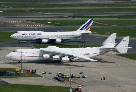 two large air france airplanes on an airport tarmac, one is white and the other is blue