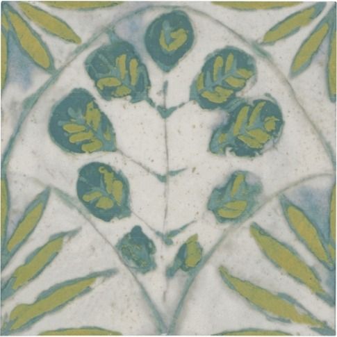 an image of some green leaves on a white surface with blue and yellow spots in the center