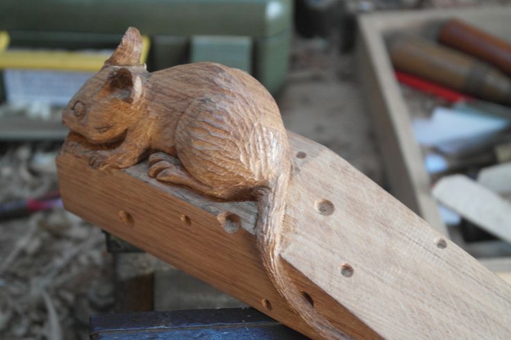 a wooden carving of a mouse on top of a piece of wood