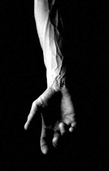 black and white photograph of someone's arm with their hand in the air