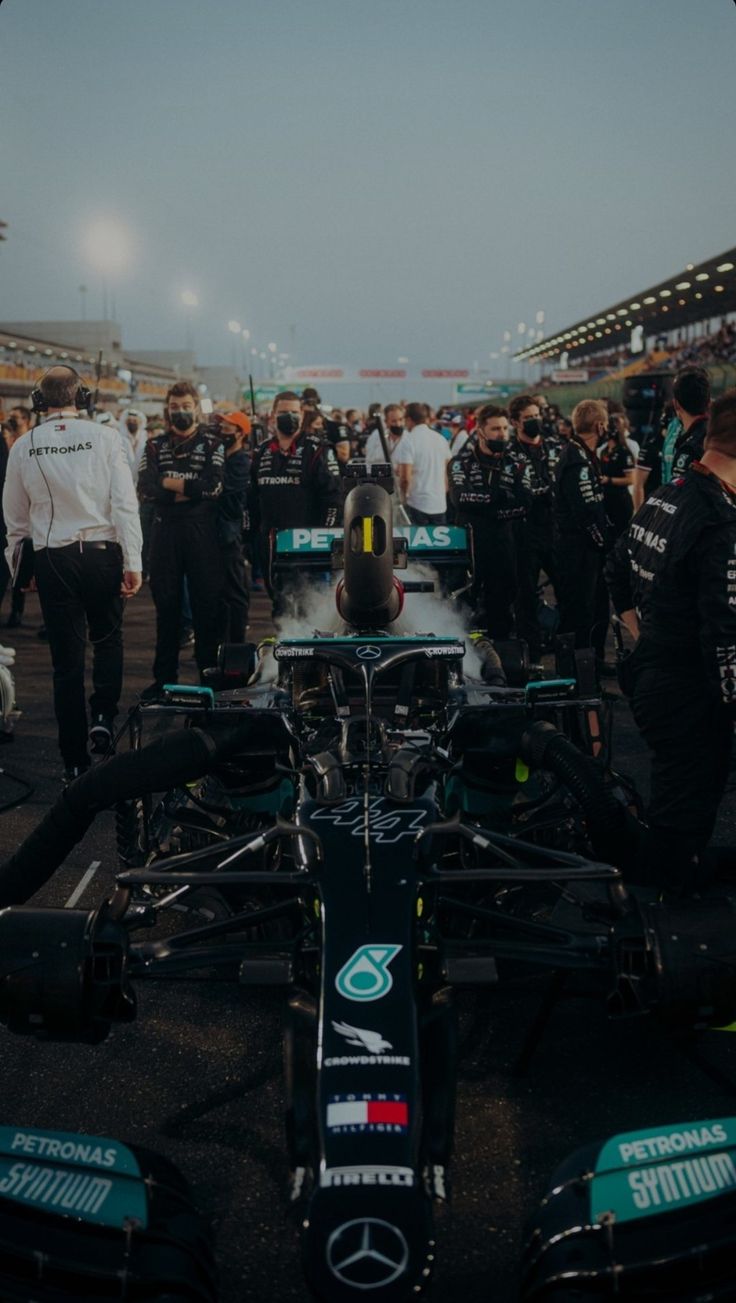 the mercedes team is gathered around their car