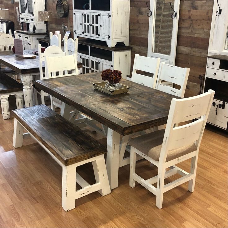 a wooden table with white chairs around it in a room filled with cabinets and other furniture