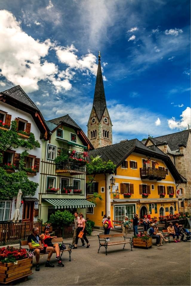 people are sitting on benches in front of buildings