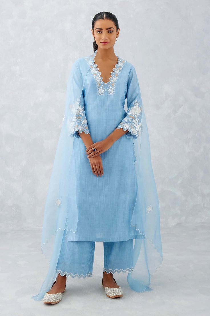 Ice blue kurta features delicate thread embroidery with cutwork details on V-shaped neckline and sleeves. Comes with a matching pant with cutwork details and a matching embroidered dupatta.
Components: 3
Pattern: Embroidered
Type Of Work: Thread Work
Neckline: Plunged V-Neck
Sleeve Type: Straight Three Quarter
Fabric: Woven Chanderi and Silk Organza
Color: Blue
Other Details: 
Wavy cutwork hem
Semi-sheer dupatta
Occasion: Puja - Aza Fashions Suit Designs Indian Style, Simple Indian Suits, Organza Kurta, Embroidery Kurti, Simple Kurti, Embroidery Suits Punjabi, Vintage Blouses, Organza Suits, Indian Outfits Lehenga