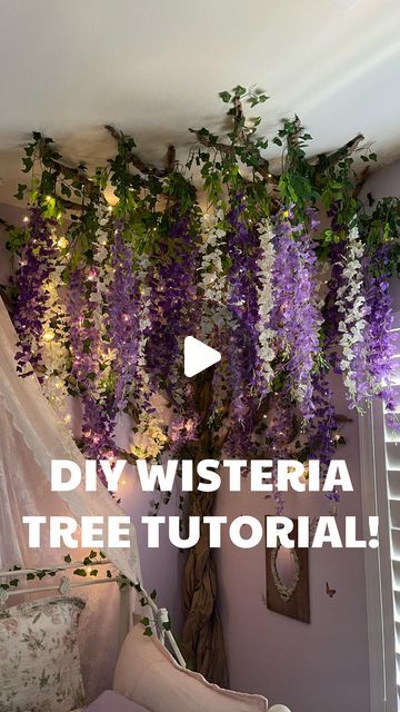 a living room filled with lots of purple flowers and greenery hanging from the ceiling