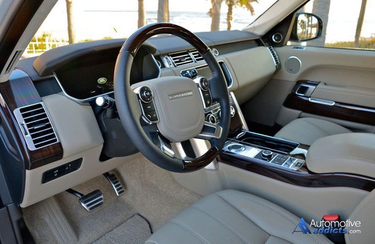 the interior of a car with beige leather and wood trims, including steering wheel