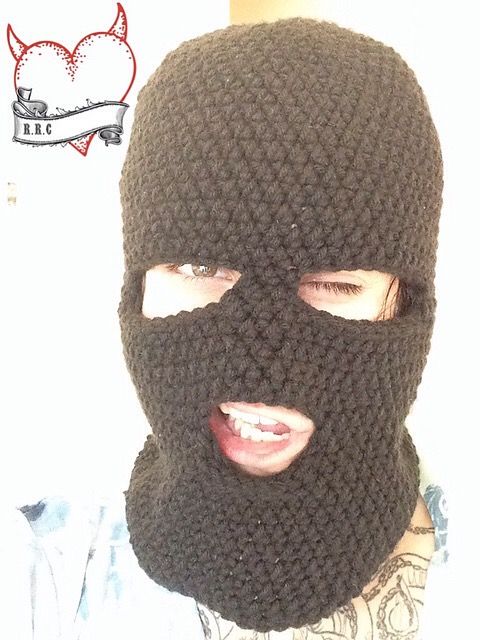 a person wearing a knitted black mask on top of their head and covering his face