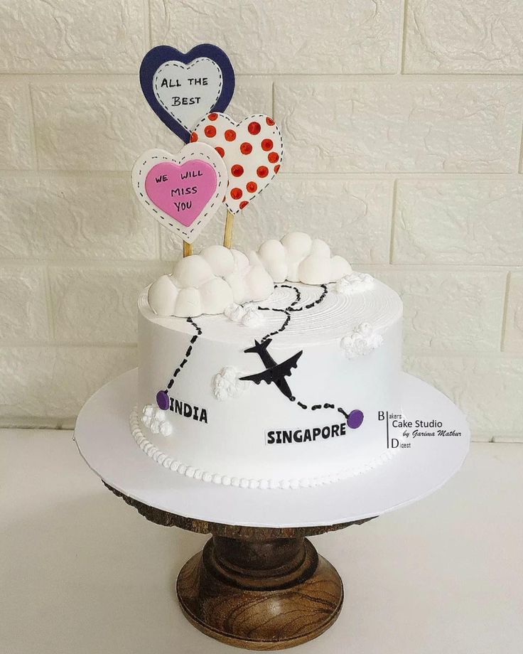 a cake decorated with two hearts and the words singapore on it is sitting on a pedestal