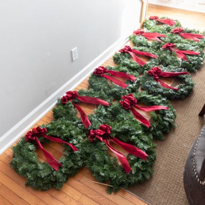 christmas wreaths are lined up on the floor