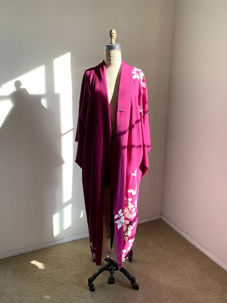 "Vintage 1950s purple silk kimono with a floral pattern.  Fits-like: One size fits most Length: 49\"  Good/Great *Some marks. Stains on the lining.  Dry clean only" Pink Floral Print Open Front Kimono, Long Pink Silk Robe, Elegant Long Purple Kimono, Pink Silk Kimono For Spring, Pink Silk Long Sleeve Kimono, Long Purple Kimono For Spring, Purple Floral Print Kimono For Spring, Spring Purple Floral Print Kimono, Purple Floral Print Kimono With Kimono Sleeves