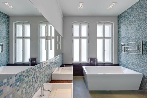 a large bathroom with two sinks and bathtubs in the same color as the walls