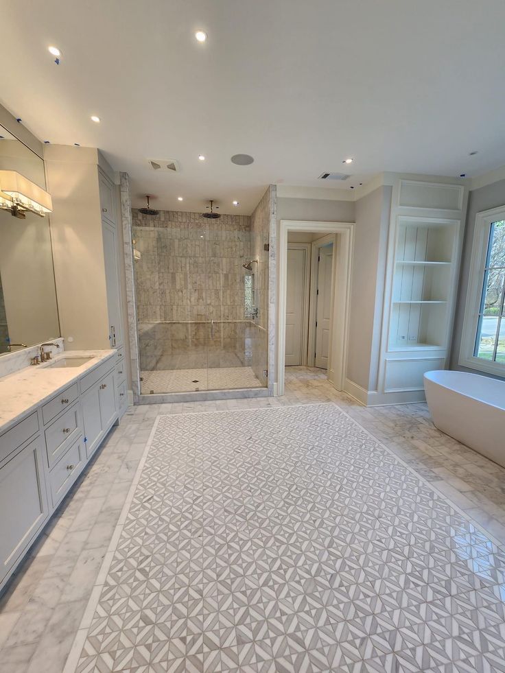 a large bathroom with a walk in shower next to a bathtub and double sinks