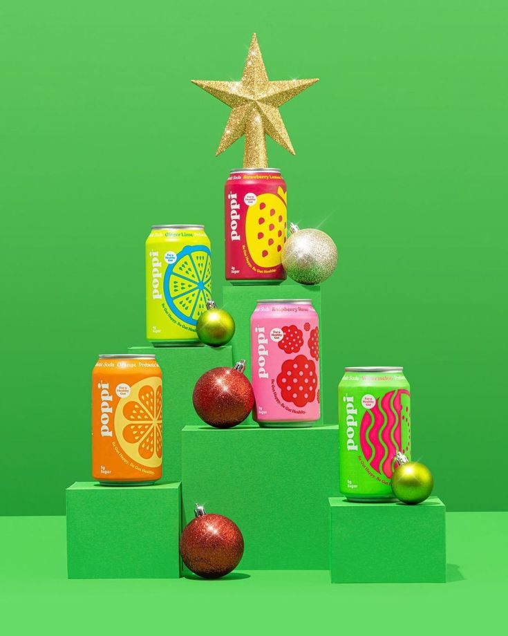 a christmas tree made out of cans with fruit on top and a star above it