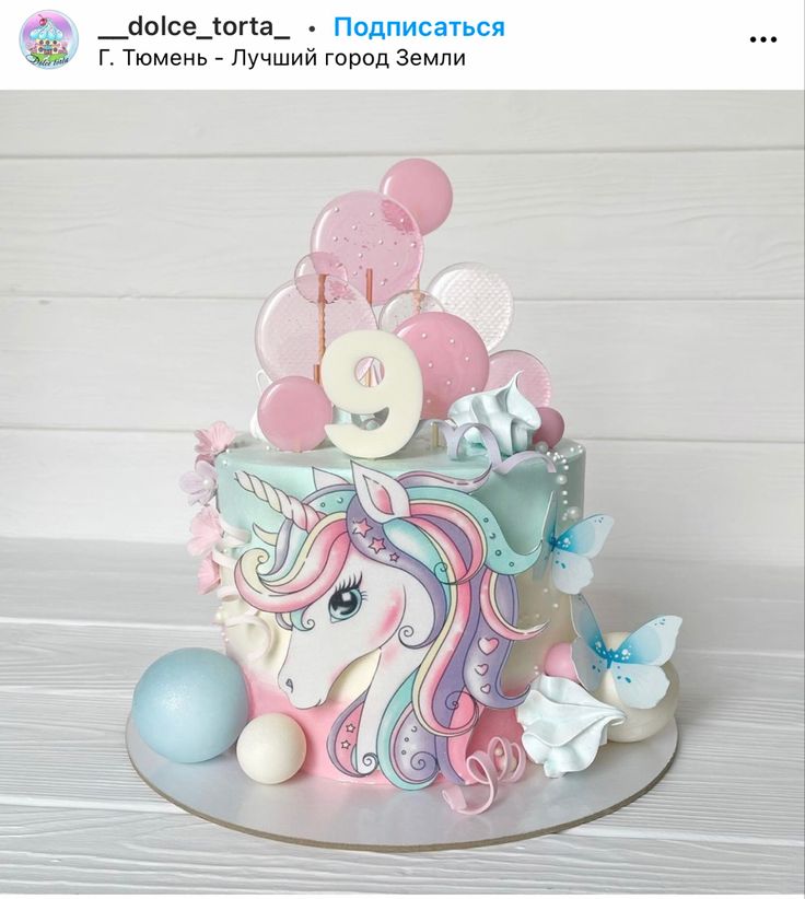 a birthday cake decorated with pink, blue and white decorations on top of a table