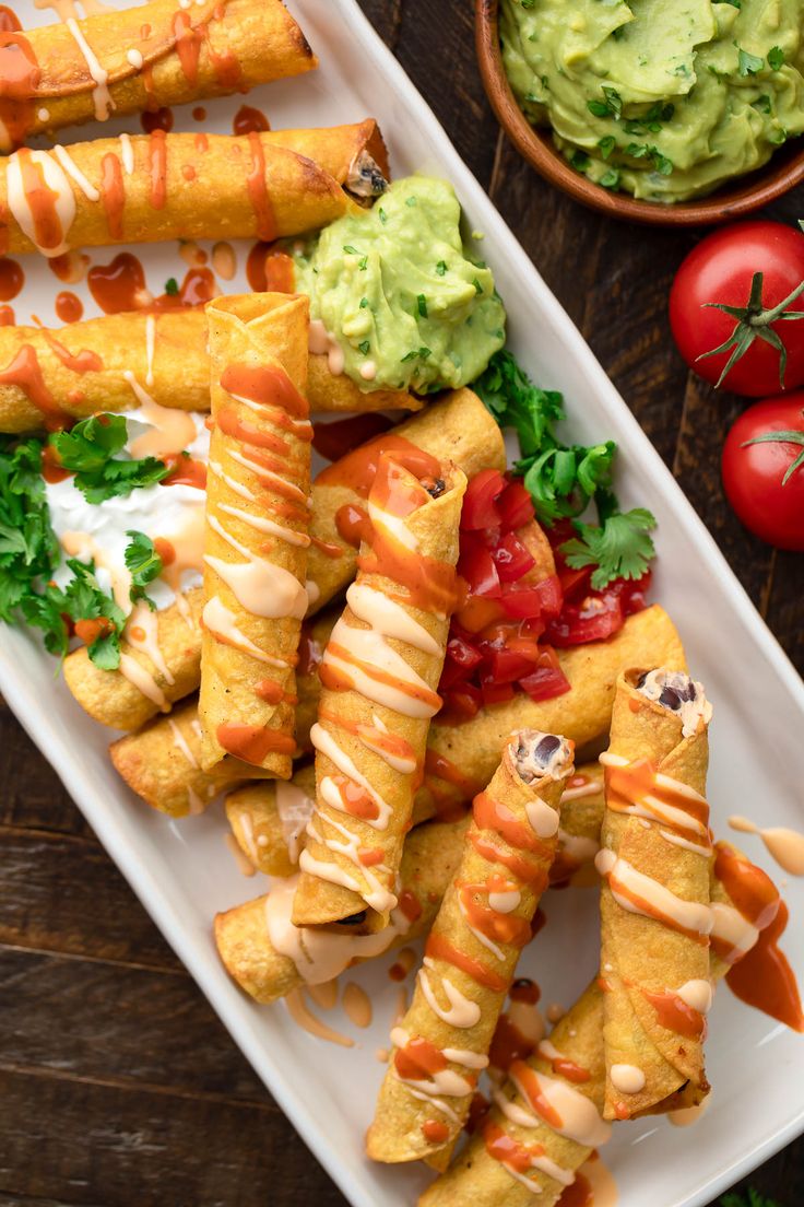 some food is on a white plate with tomatoes and guacamole