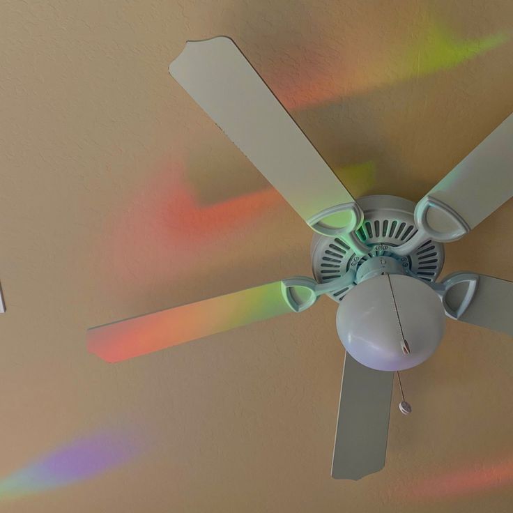 a ceiling fan with multicolored light coming from it