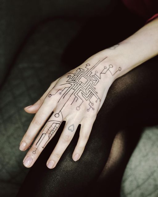 a woman's hand with an intricate tattoo design on her left arm and wrist