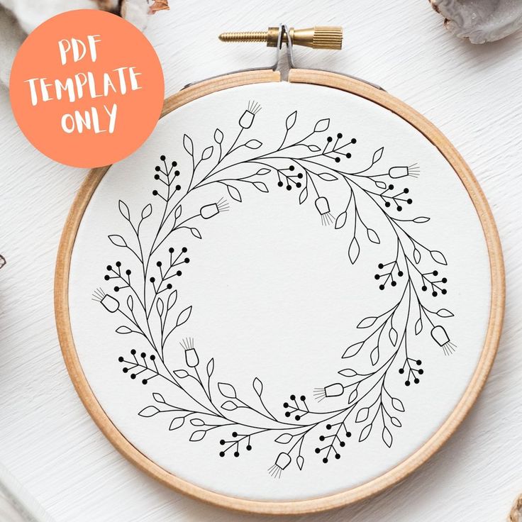 the embroidery pattern is being displayed in front of an orange circle with leaves on it