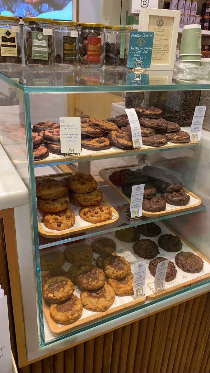 a display case filled with lots of different types of cookies and muffins next to each other