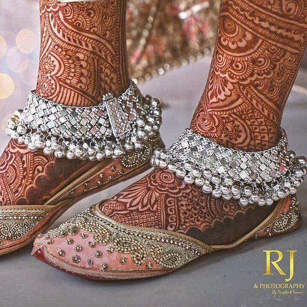 the feet and ankles of a woman wearing high heels with beaded decorations on them