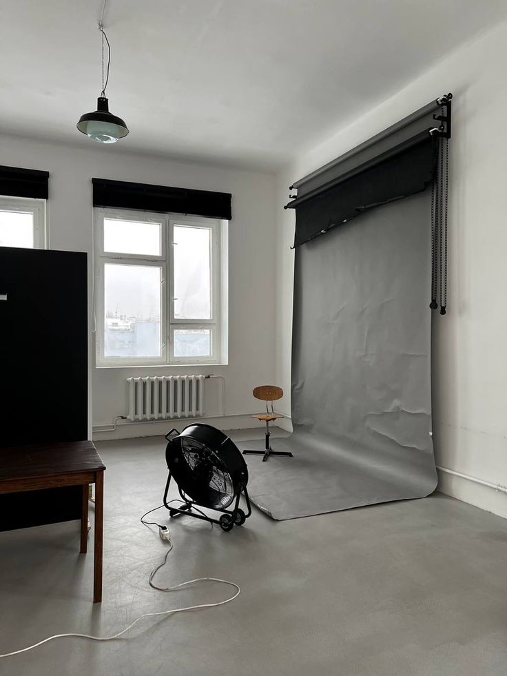 an empty room with a black and white photo on the floor next to a large window