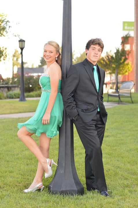 a man and woman standing next to a lamp post