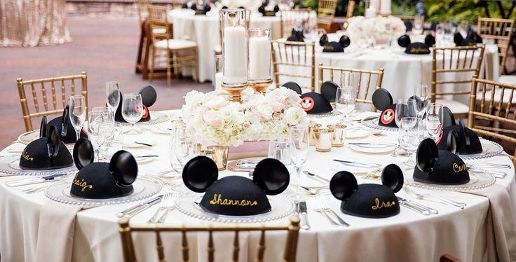 the table is set with mickey mouse hats and place settings for guests to sit at