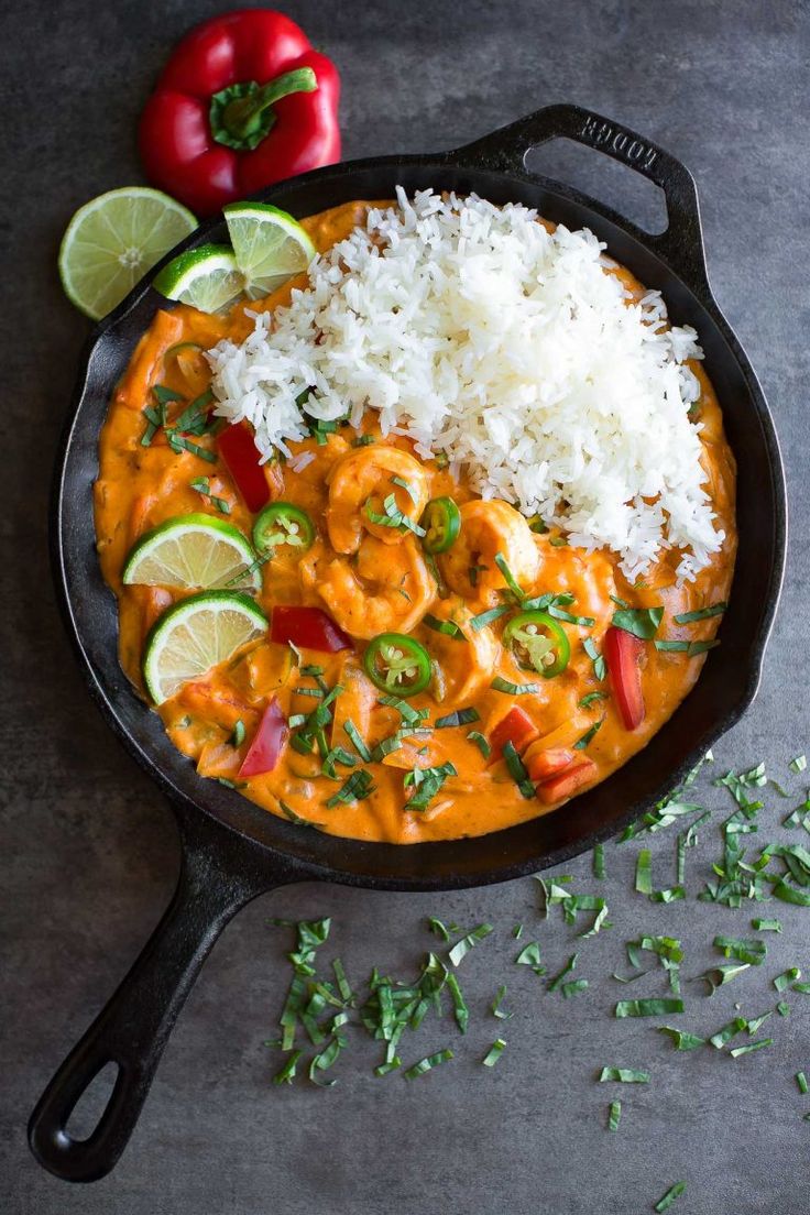 a skillet filled with shrimp and rice, garnished with cilantro