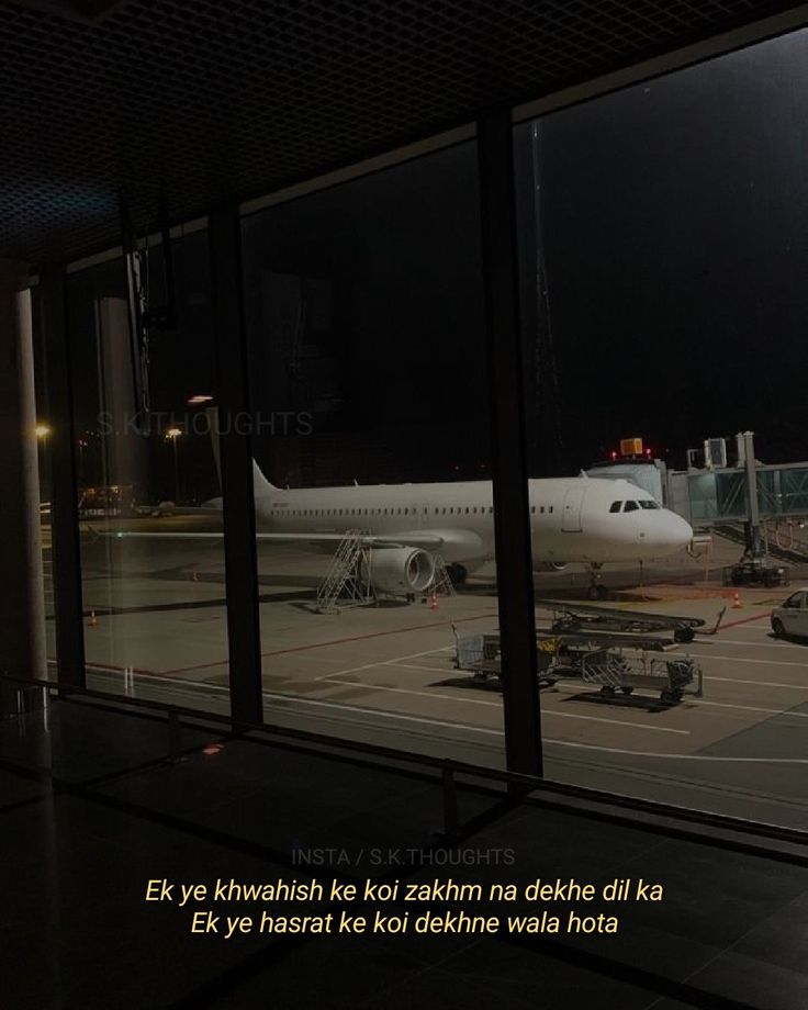 an airplane sitting on the tarmac at night