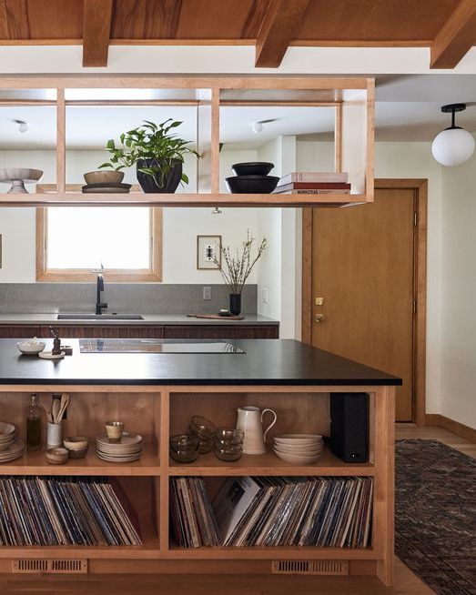 a kitchen with an island and shelves filled with record's on the counter top