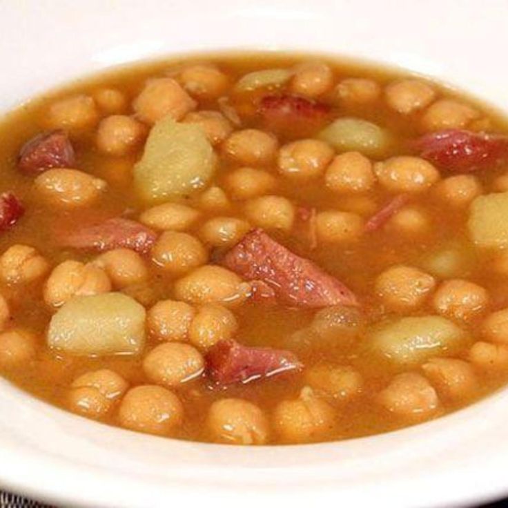 a white bowl filled with beans and ham