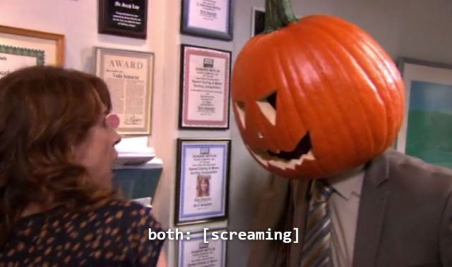 a woman standing next to a man in a suit and tie with a pumpkin on his head