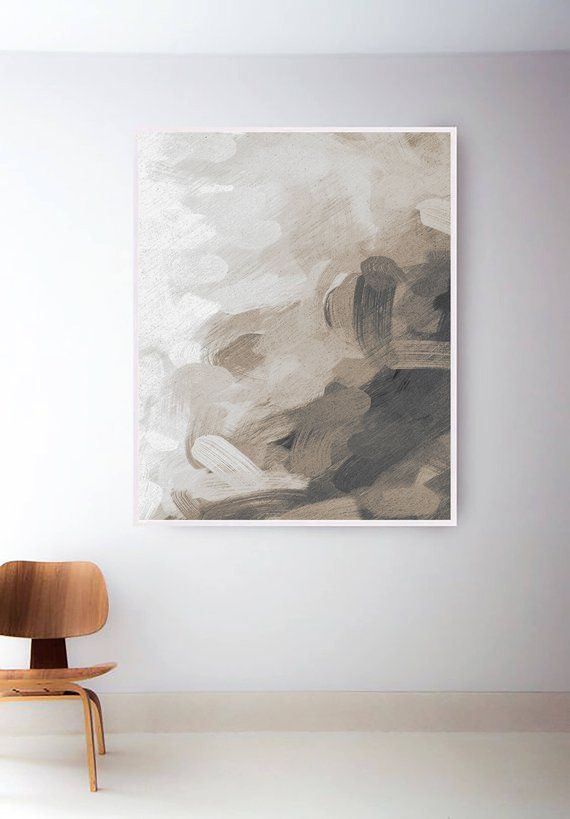 a chair sitting in front of a white wall with a painting hanging on the wall