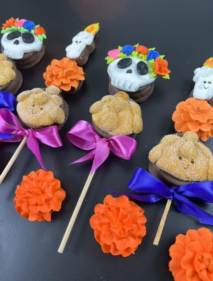 there are many cupcakes decorated to look like skulls and flowers on the sticks