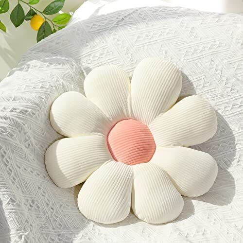 a flower shaped pillow on top of a white blanket