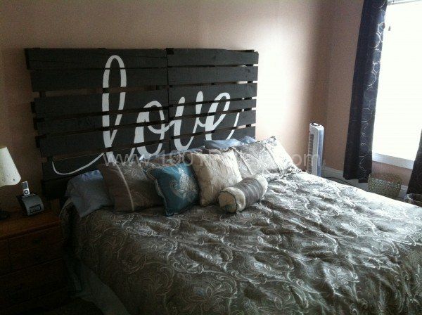 a bed made out of pallet wood with the word love spelled on it's headboard